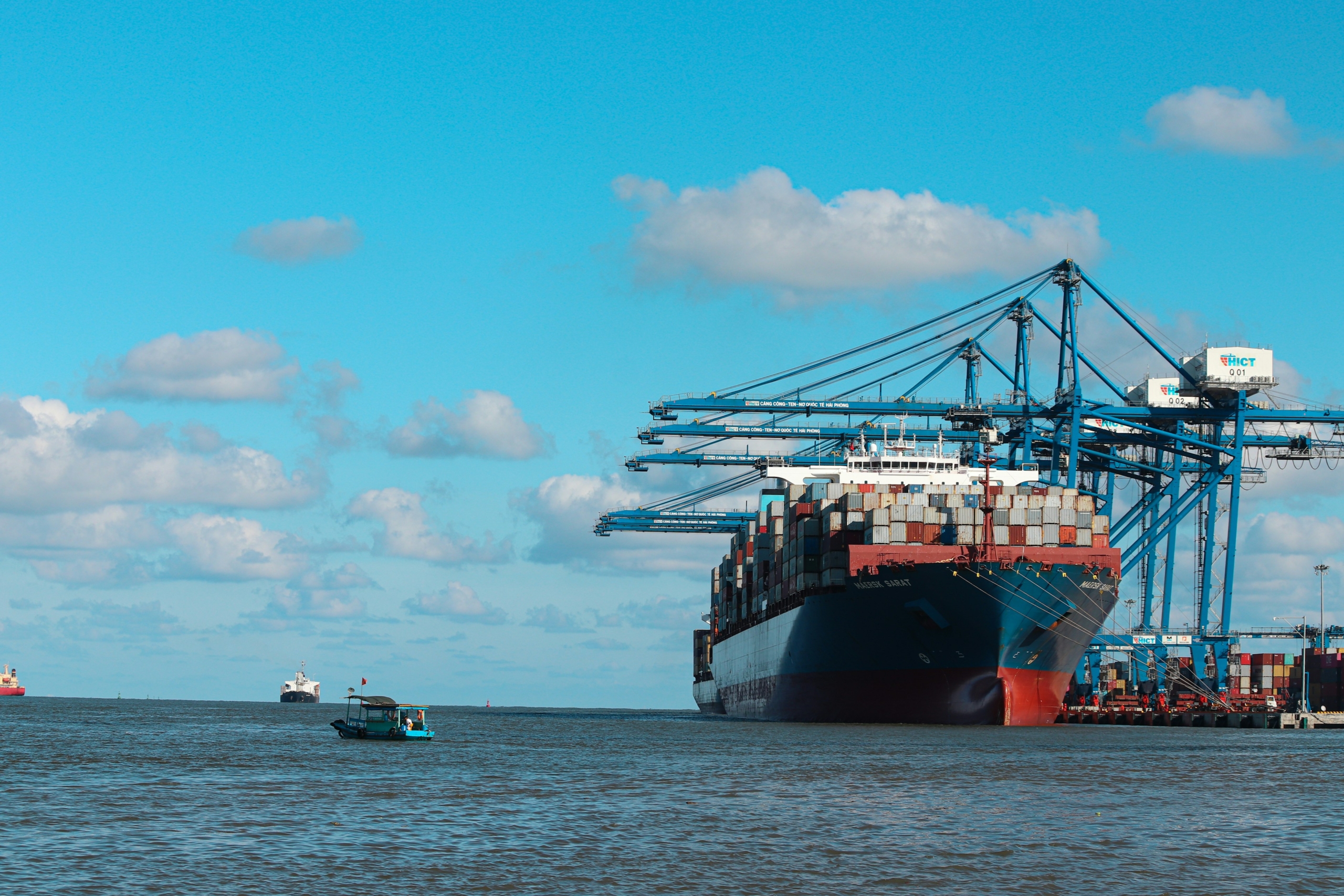 Container ship in harbor below large cranes
